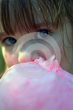 Close up of young girl eating cotton candy