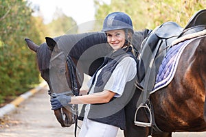 Close-up of a young girl hugged the horse`s face with her hands.