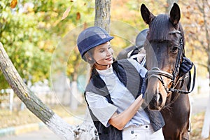 Close-up of a young girl hugged the horse`s face with her hands.