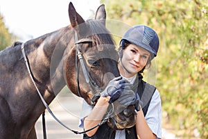 Close-up of a young girl hugged the horse`s face with her hands.