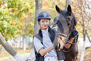 Close-up of a young girl hugged the horse`s face with her hands.