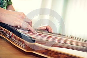 Close up of young girl's hand playing on zither photo
