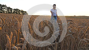 Close up of young girl in sunglasses going with her dog across spikelets at meadow. Cute siberian husky pulling the