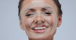 Close-up of young girl touching her face. Woman with perfect skin on grey background. Skin care treatment or cosmetic