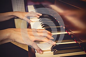 Close up of young girls hands, playing piano. vintage tone filte