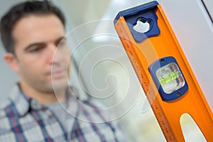 Close up young handyman using spirit level