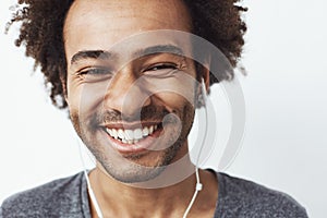 Close up of young happy african man smiling laughing over white background.