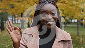 Close-up young happy joyful african american woman looking at camera posing outdoors showing ok gesture of approval