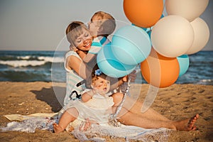 Close up of young happy loving family with small kids, having fun at beach together near the ocean, happy lifestyle family concept