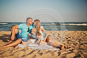 Close up of young happy loving family with small kids in the middle, having fun at beach together near the ocean, happy lifestyle