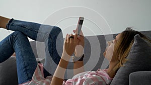 Close up of young happy smiled woman chatting on the mobile phone and laughing. Indoor. Beautiful woman using smartphone chatting