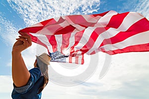 Close up young happy woman holding United States of America flag