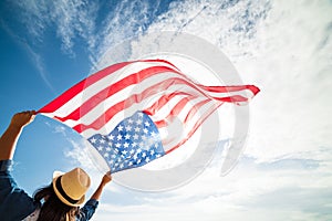 Close up young happy woman holding United States of America flag