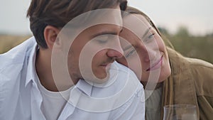 Close-up young happy woman putting head on shoulder of man looking away smiling. Loving Caucasian girlfriend enjoying