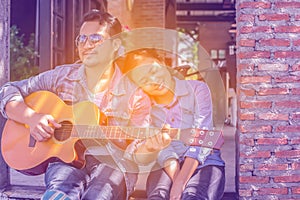 Young hipster practiced guitar in the park,happy and enjoy playing guitar. photo