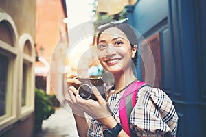 Close up of young hipster woman backpack traveling taking photo with her camera