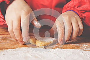 Close up young little chef girl with cook hat and apron preparing sweet desert at home kitchen