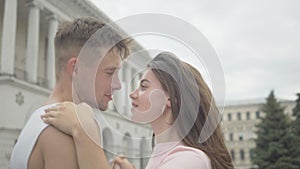 Close-up of young loving Caucasian couple dancing on city square. Portrait of happy joyful man and woman enjoying dance