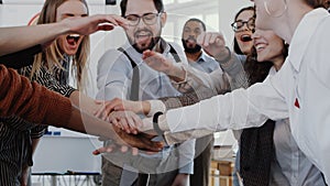 Close-up young male boss joining hands with multiethnic team celebrating success at modern office slow motion RED EPIC.