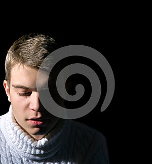 Close-up of young man on black background, low key,