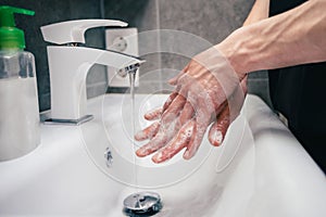 Close up. young man is carefully soaping his hands .