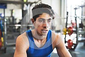 A close up of a young man in crossfit gym, resting after an exercise.