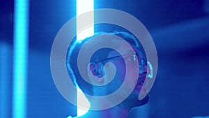 Close-up of a young man dancing in a nightclub under a neon light. Night club