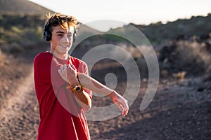 Close up of young man doing exercise outdoors and stretching after workout - runner or jogger training to be healthy and fit