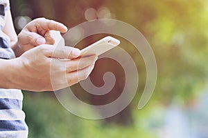 Close up of a young man hand holding using mobile smart phone outdoor