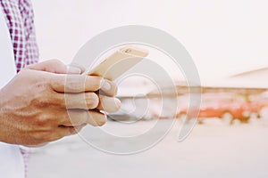 Close up of a young man hand holding using mobile smart phone outdoor