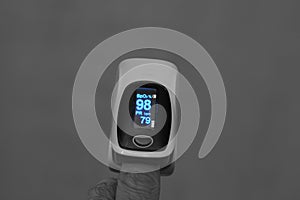 Close-up for a young man hand with a pulse oximeter that measures the oxygen saturation of the blood and the pulse rate