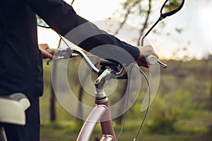 Close up of young man having fun near countryside park, riding bike, traveling at spring day