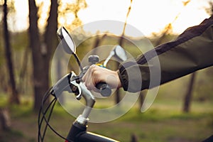 Close up of young man having fun near countryside park, riding bike, traveling at spring day