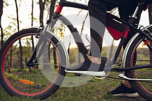 Close up of young man having fun near countryside park, riding bike, traveling at spring day