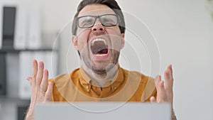 Close Up of Young Man with Laptop Shouting in Office, Failure