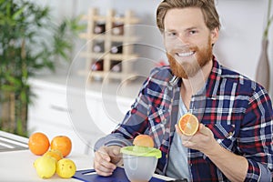 close up young man making orange juice