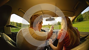 CLOSE UP: Young man pointing where the couple will drive during their road trip.