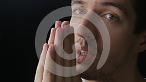 Close up of young man praying to God. Concept of faith and religion