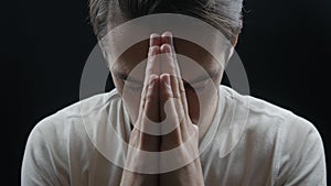 Close up of Young man praying to God. Concept of faith and religion