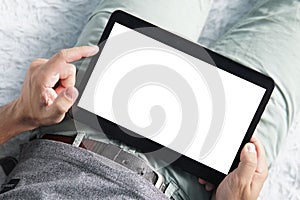 Close up of a young man raising the left index finger over the white screen of a digital tablet. Person starts working on tablet