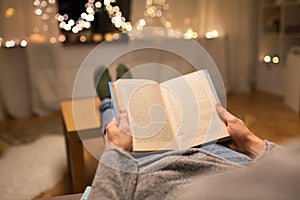 Close up of young man reading book at home