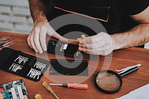 Close up Young Man Repairing Mobile Phone at Table