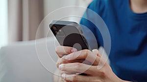 Close up of young man typing the smart phone for chatting on the sofa. searching, browsing, shopping online, social network