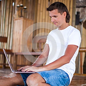 Close up young man using tablet computer on exotic
