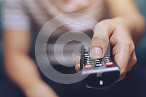 Close up young man is using television remote contro photo