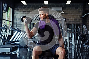 Close Up of a muscular young man lifting weights in gym photo