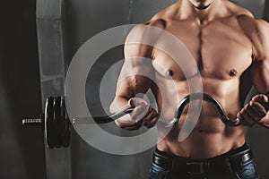 Close up of young muscular man lifting weights