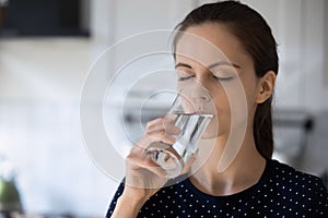 Woman holds glass drinking still water reducing thirst photo