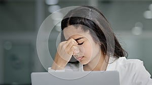 Close-up young sad tired woman manager looking at laptop screen in office feeling exhausted headache fatigue after using