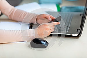 Close up of young school girl working at home in her room with a laptop and class notes studying in a virtual class. Distance